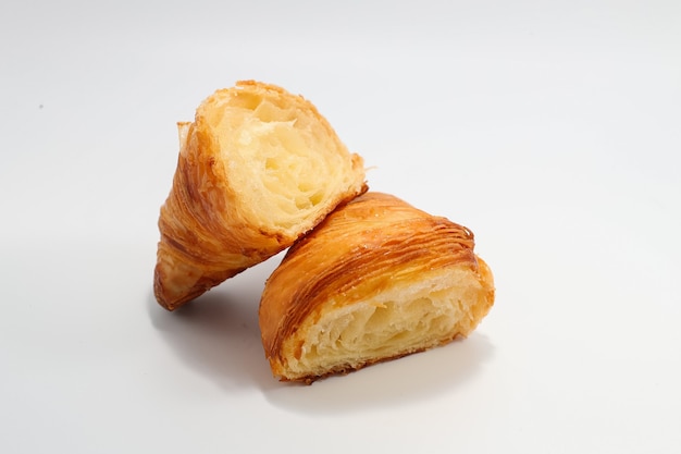 Croissant tradicional recién horneado cortado en dos partes