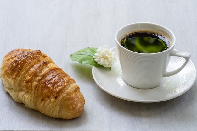 Croissant und kaffee auf weißem tisch