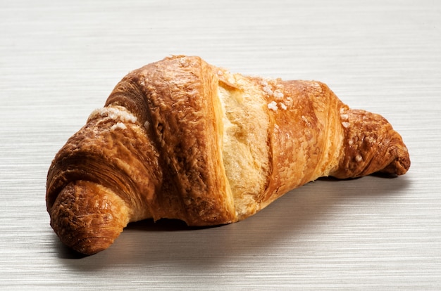 Croissant único na mesa branca