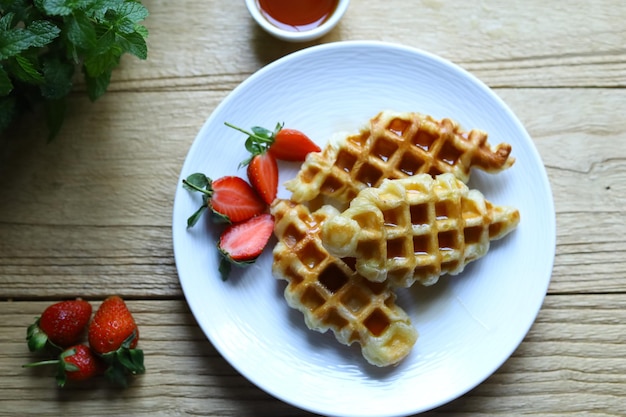 Croissant Waffle o croffle en plato blanco con fresa