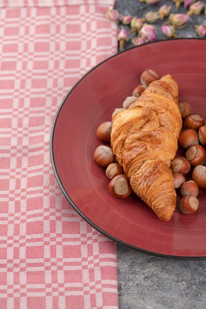 Croissants acabados de fazer com avelãs saudáveis com casca.