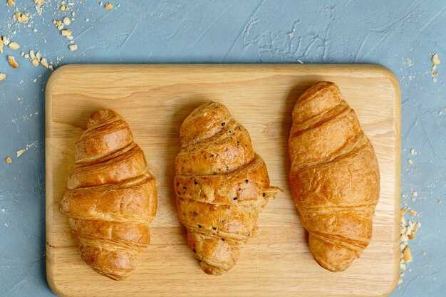 Croissants acabados de fazer na placa de madeira, vista superior.