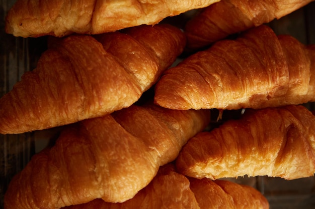 Croissants assados fecham a textura. Conceito de padrão de muitos croissants.