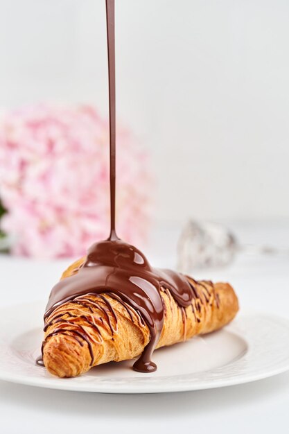 Croissants auf einem mit Schokolade bestreuten Teller Ein selektiver Fokus Offene Blende