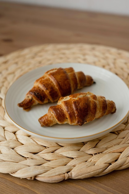 Croissants auf einem weißen Teller auf einem hölzernen Hintergrund, selektiver Fokus