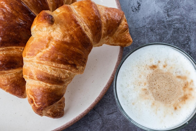 Croissants con café capuchino en la mesa