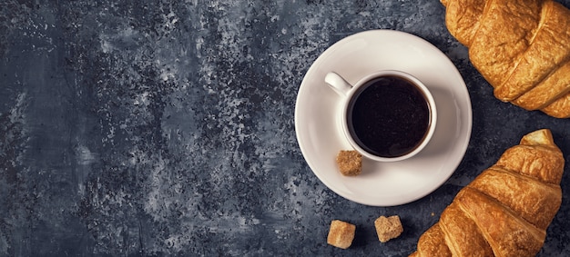 Croissants y café en una mesa oscura