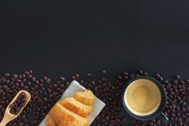 Croissants calientes de café, frijoles y mantequilla en la mesa negra