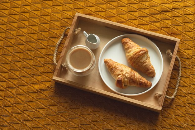 Croissants caseros y café en una bandeja de madera