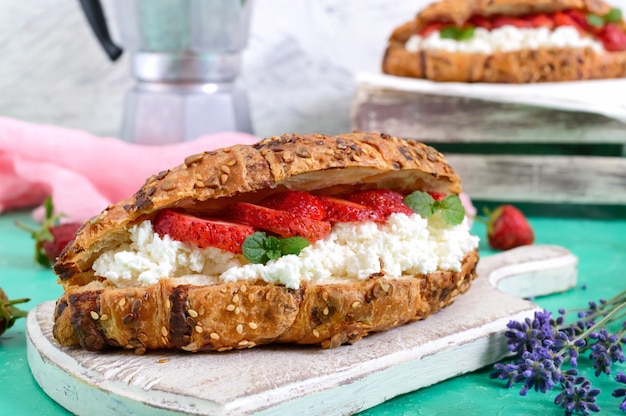 Croissants de cereales con queso crema y fresas frescas. Desayuno útil Nutrición apropiada. Platos tradicionales franceses.