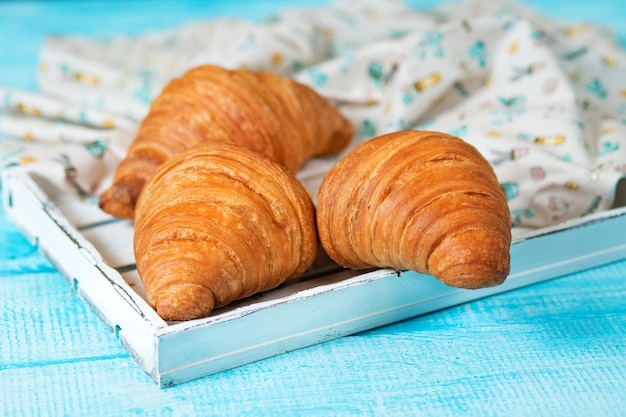 Croissants de cocina francesa sobre un fondo azul Productos de panadería Bollo dulce de croissant francés