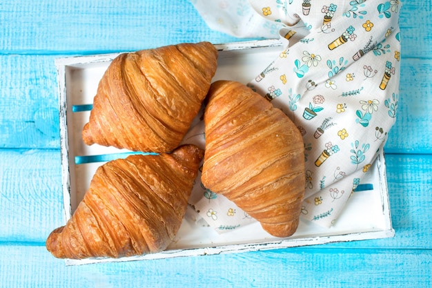 Croissants de cocina francesa sobre un fondo azul Productos de panadería Bollo dulce de croissant francés