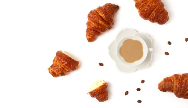 Croissants com uma xícara de café, sobre fundo branco, vista de cima, sem pessoas, horizontal. Foto de alta qualidade