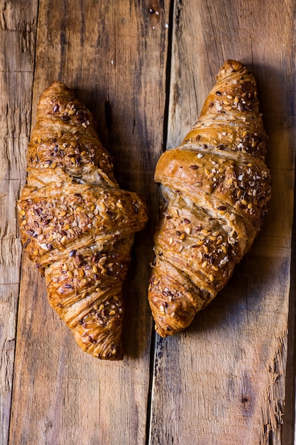 Croissants de trigo integral amanteigado assado com sementes de gergelim no celeiro resistido