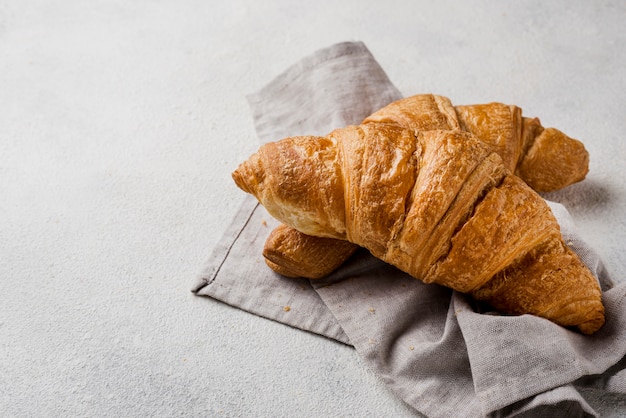 Croissants deliciosos de vista frontal em pano de cozinha