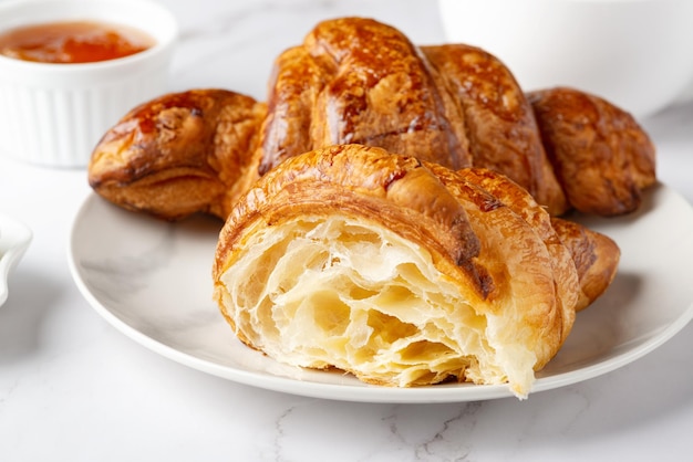 Croissants doces frescos com geléia de damasco no café da manhã Café da manhã continental em uma mesa branca