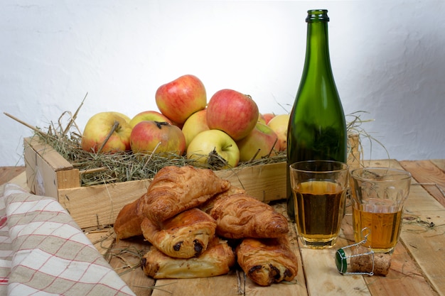 Croissants y dolores al chocolate con una caja de manzanas