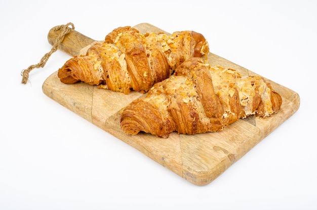 Croissants dulces frescos para el desayuno en blanco. Foto de estudio