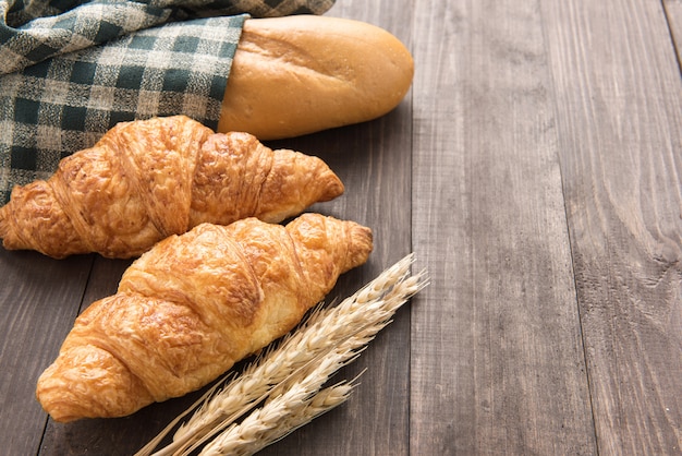 Croissants e baguete na mesa de madeira