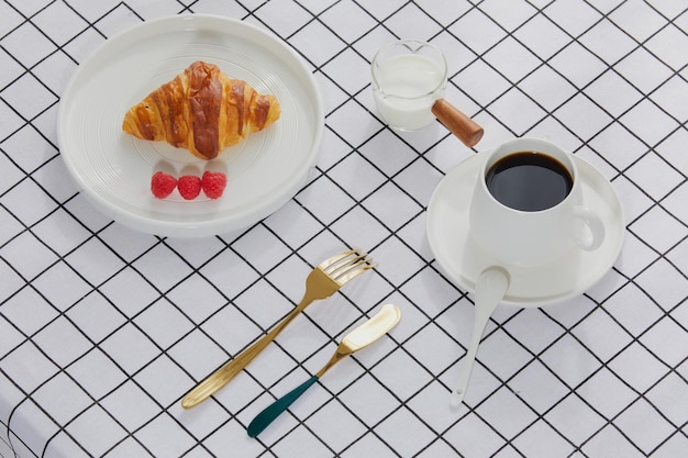 Croissants e café em uma toalha de mesa tartan