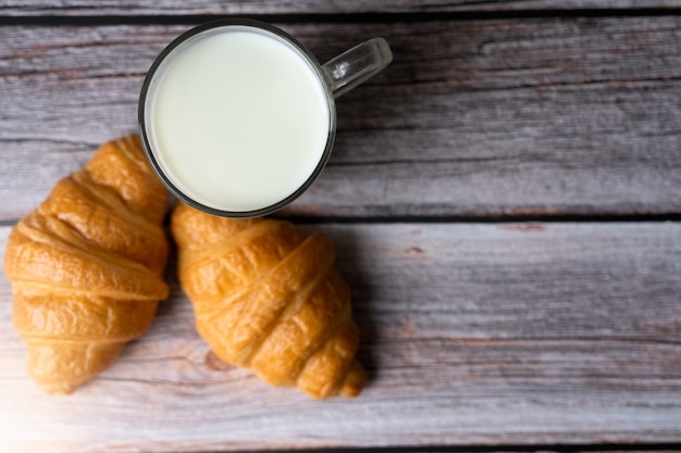 Croissants e leite na mesa. Comida para o conceito de pequeno-almoço