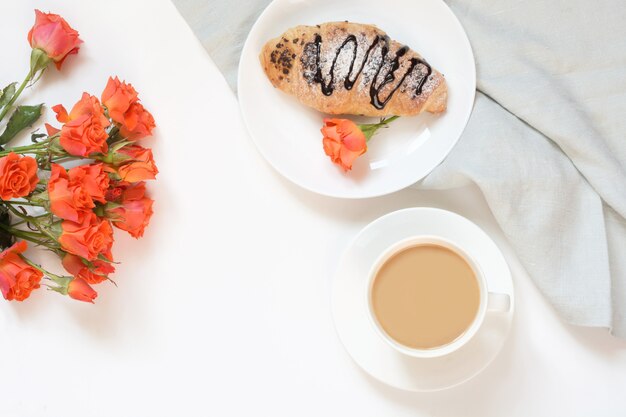 Croissants e xícara de café recentemente cozidos do chocolate na tabela branca. vista do topo. café da manhã feminino. copie o espaço.