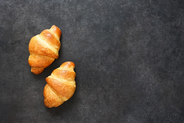 Croissants em uma mesa de concreto preto. vista de cima.