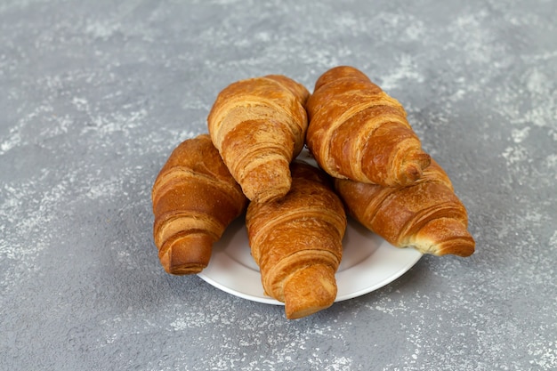 Croissants franceses frescos em mesa de pedra cinza