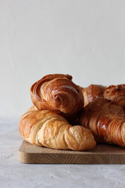 Croissants franceses na placa de madeira no fundo cinza com copyspace