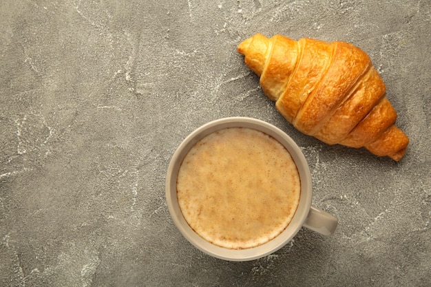 Croissants franceses no prato e café no fundo de concreto