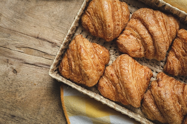 Croissants frescos caseros franceses sobre mesa de madera