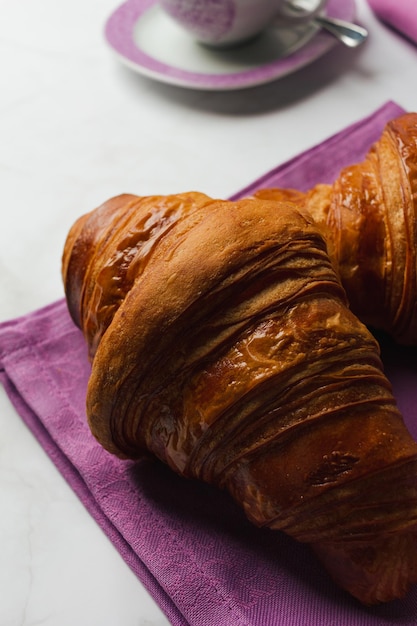 Croissants frescos com café no fundo de mármore. Delicioso café da manhã ou lanche com foco seletivo