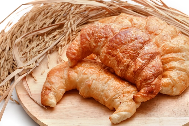 Croissants frescos deliciosos com arroz no fundo de madeira