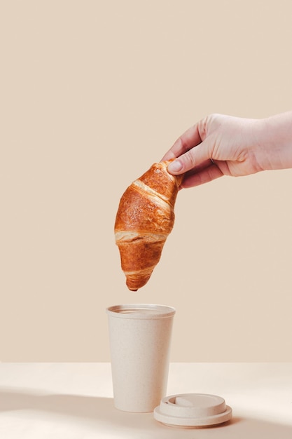 Foto croissants frescos e deliciosos com um copo ecológico sobre um fundo claro amabilidade ambiental uso secundário