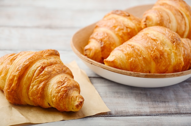 Croissants frescos na mesa de madeira.