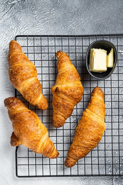 Croissants horneados en una rejilla para enfriar Fondo blanco Vista superior