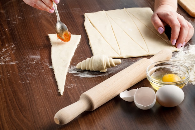 Croissants machen auf Holztisch mit Mehl