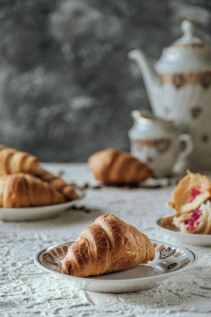 croissants macios frescos estão sobre um fundo de concreto de mesa branca e bolos