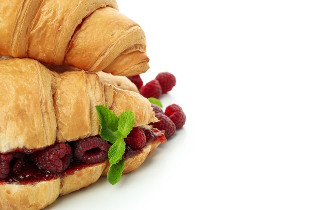 Croissants con mermelada de frambuesa aislado sobre fondo blanco.