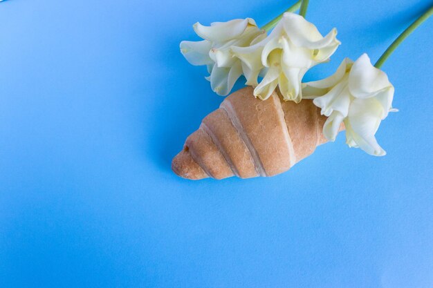 Croissants mit Blumen auf blauem Hintergrund.