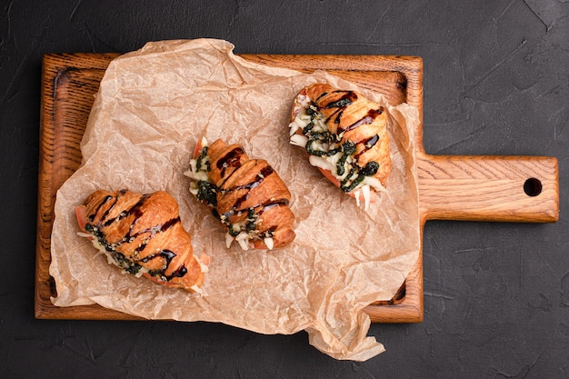 Croissants mit Füllungen Croissants mit verschiedenen Füllungen auf schwarzem Hintergrund