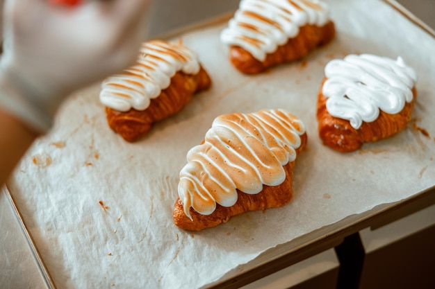 Croissants mit gebrannter und weißer Eiweißcreme auf Tablett in Bäckerei