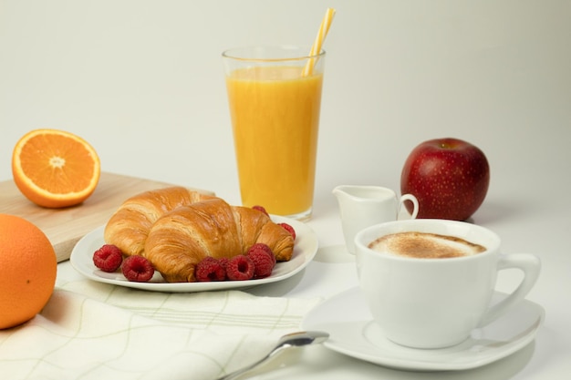 Croissants mit Kaffee und köstlichen frischen Himbeeren