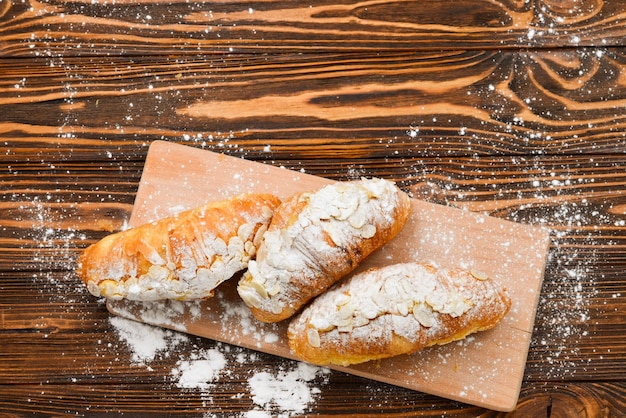 Croissants mit Mandeln und Tee auf einem Holztisch