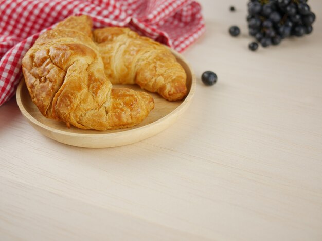 Croissants en placa de madera con copia espacio.