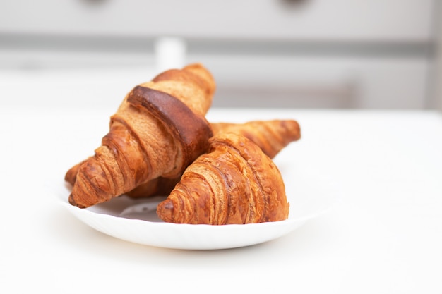 Croissants en un plato blanco. El desayuno es delicioso y saludable.