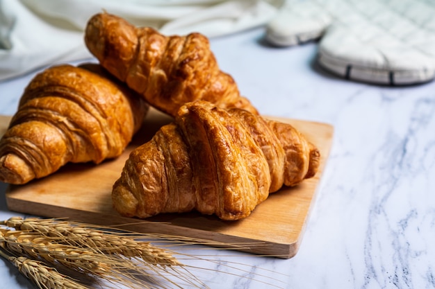 Croissants recém-assados na tábua de madeira.