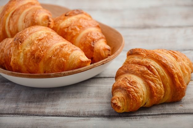 Croissants recién hechos en la mesa de madera.