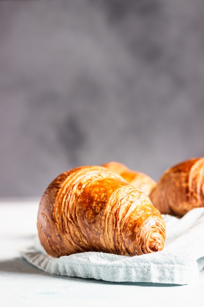 Croissants recién hechos en una servilleta de lino gris