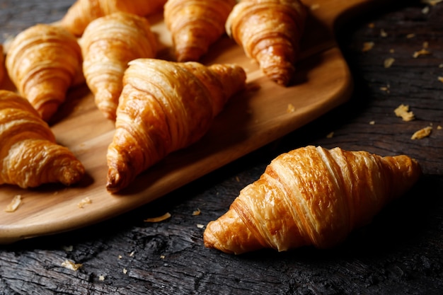 Croissants recién horneados sobre tabla para cortar madera